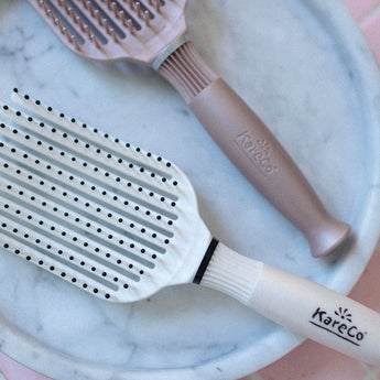 Tangle Buster Brush Pearl + Cashmere in marble trinket dish.