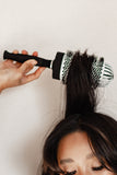 Lady creating massive volume from the crown of her head with the jumbo round brush.